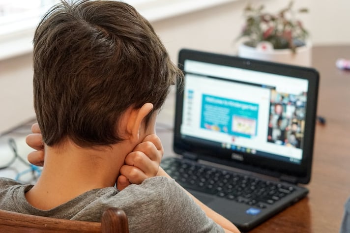 Un ragazzo passa il suo tempo davanti ad un computer portatile