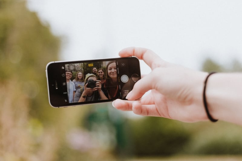 Un gruppo di ragazzi scatta un selfie con lo smartphone